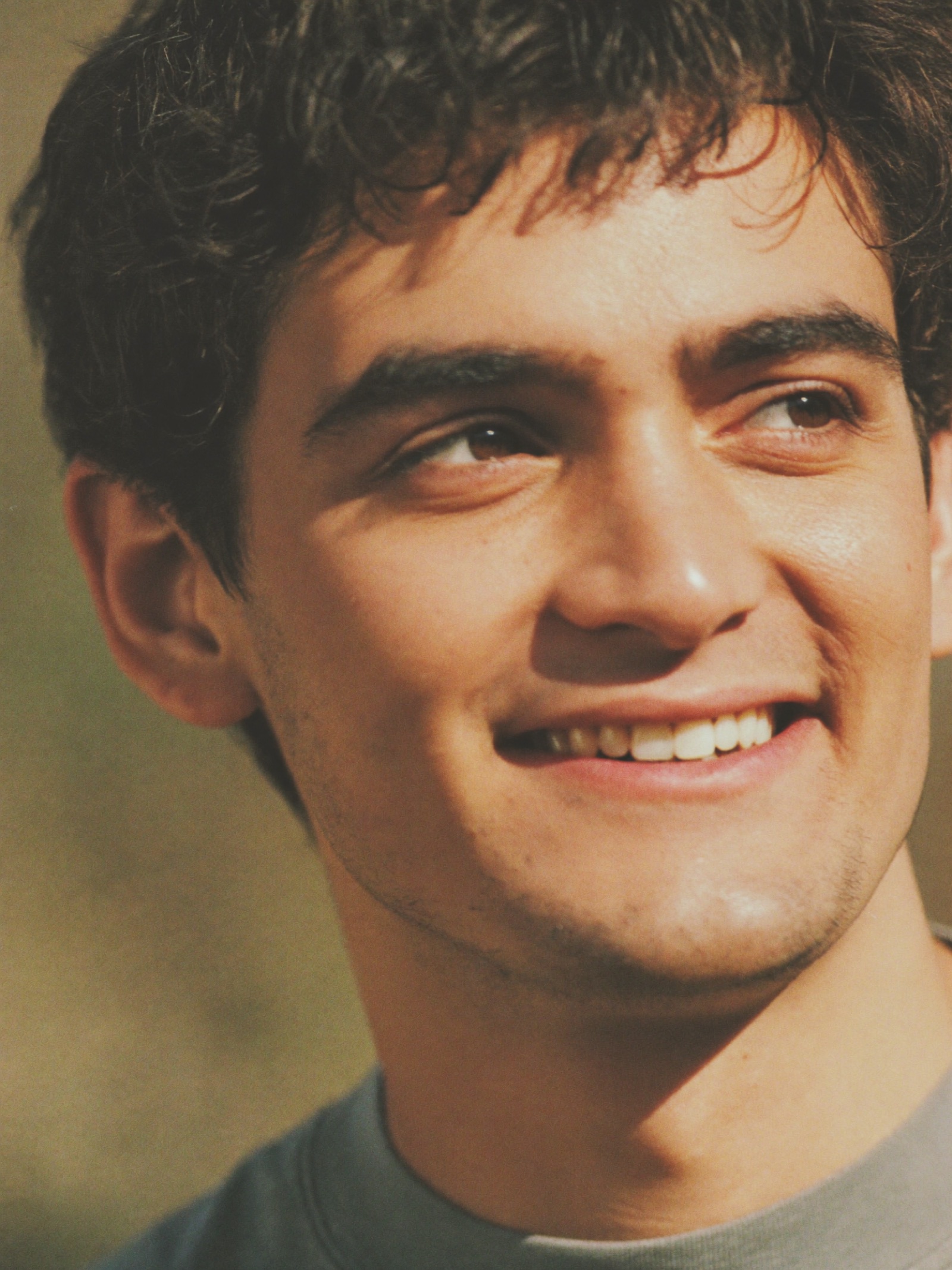A young man with a hopeful smile